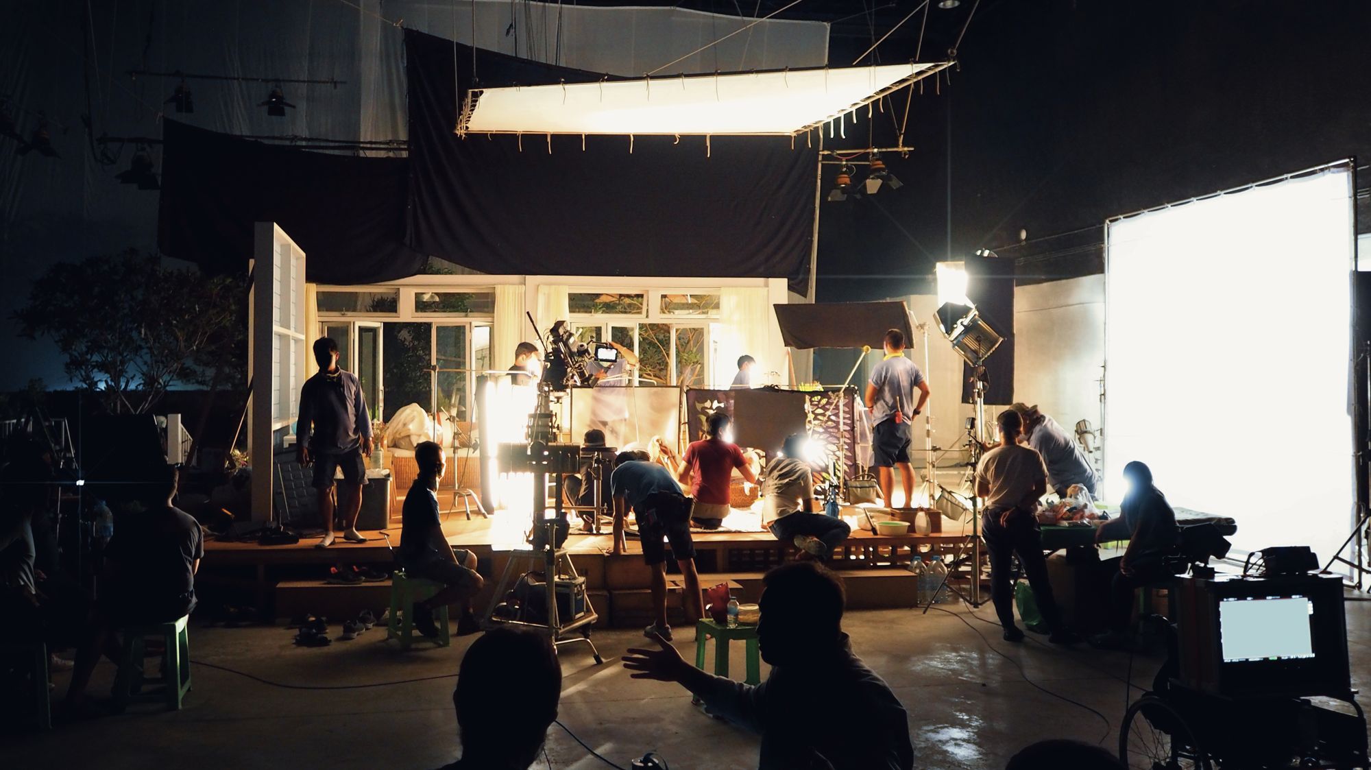 Crew working on a large, warmly lit film set